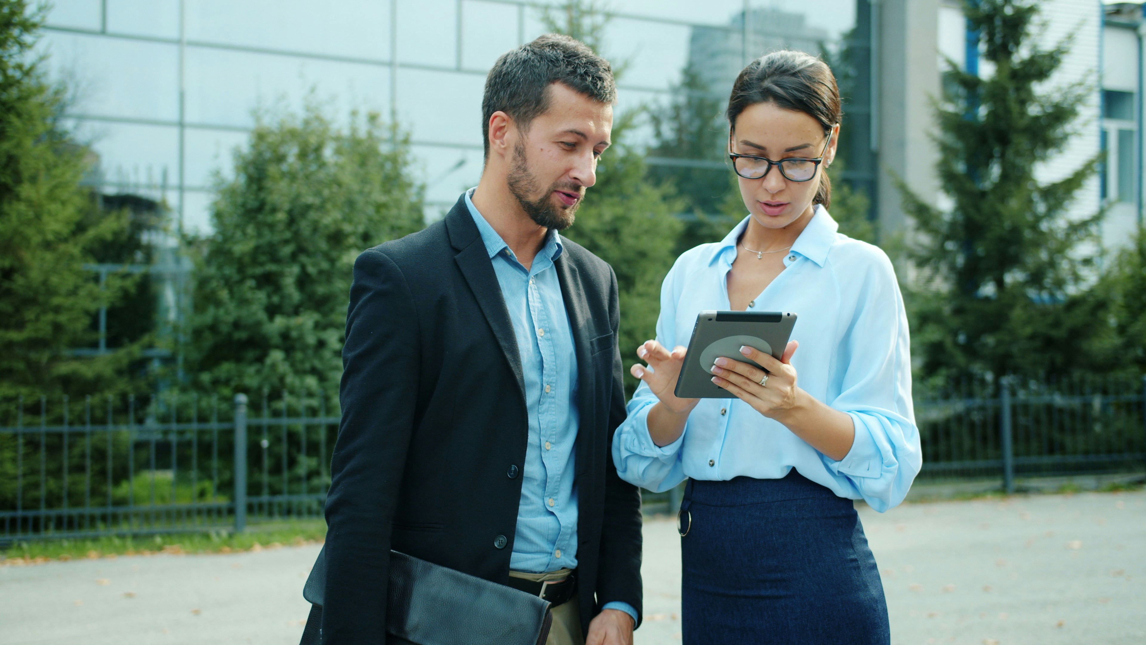 Twee professionals stemmen op locatie werkzaamheden af met een tablet